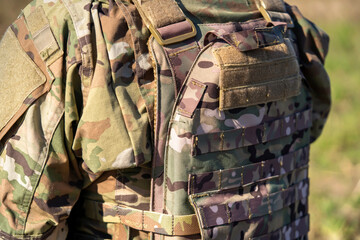 A military uniform with a body armor in camouflage closeup.