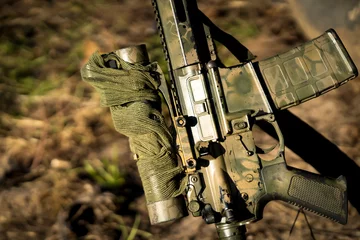 Schilderijen op glas Arch weapon, carbine in camouflage colors for hunting outdoors. © Zhanna