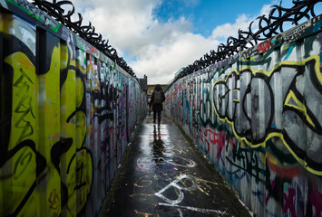 Woman walking through graffiti in London