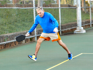 Active Senior Man playing Pickle Ball outdoors