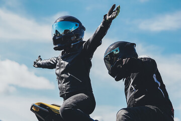 Motorcycle stung team wearing black with reflective tinted helmets, blue visor motorbike tricks