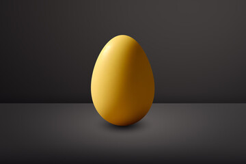 yellow Egg in front of a black wall and on a black floor