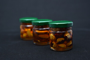 Glass jars with nuts in honey. Delicious sweets. Nuts in honey. Sweet nuts.
