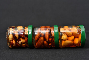 Glass jars with nuts in honey. Delicious sweets. Nuts in honey. Sweet nuts.
