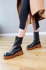 Close-up of female legs in black leather chelsea boots. Women's comfortable spring casual shoes. Black women's spring chelsea boots