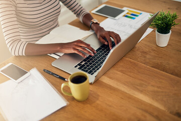 Shes got a good stream of ideas flowing. Cropped shot of an unrecognizable woman working on her laptop at home.