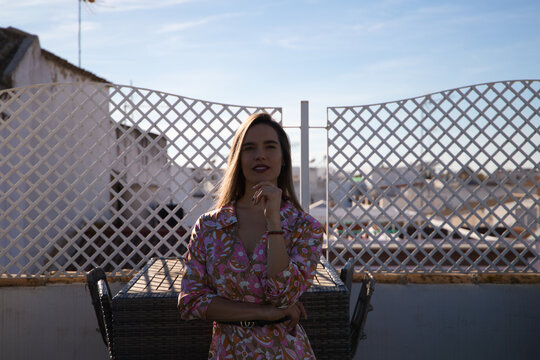 Young and beautiful blonde woman on the roof of a building in Spain. The woman is enjoying the day and sunbathing while posing for pictures making different expressions.