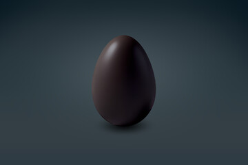 black chocolate Easter egg on a dark floor