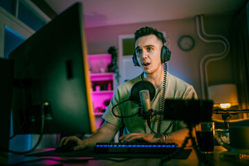 Young man male gamer playing computer game streaming video losing