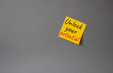 Unlock your Potential symbol. Concept words Unlock your Potential on orange steaky note. Beautiful grey background. Business and Unlock your Potential concept. Copy space.