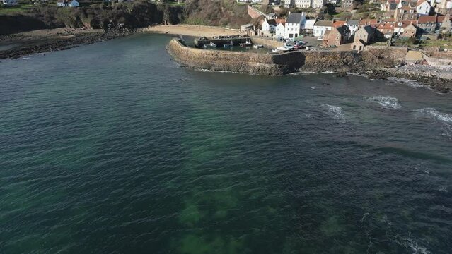 Crail, a historic fishing village on the east coast of Scotland in the East Neuk of Fife. Low level aerial footage of the pretty little harbour. Lovely reflections of whitewashed houses in the water.