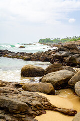 Fototapeta na wymiar Beautiful tropical landscape. A stone ocean shore with waves and rocks. Beautiful texture background for tourism, design and advertising