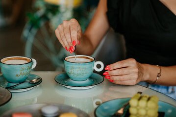 woman details hands drinking coffee eating cakes and macaroons popsi nails inspo aesthetic