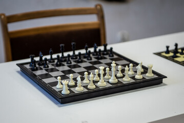 Chess player holding a piece and playing chess on a chessboard in the background, game tournament concept