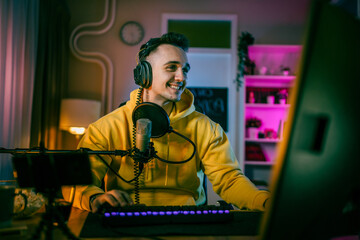 Young man male gamer playing computer game streaming video online