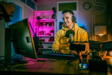 Young man male gamer playing computer game streaming video online