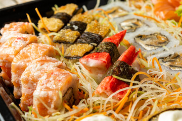 sushi combo. japanese food with lots of items, such as nigiri, hot roll, uramaki, hossomaki, sashimi, kani and others.