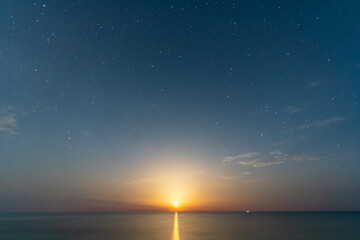 Mondaufgang über dem Meer in sternenklarer Nacht