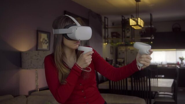 Young Woman Playing Virtual Reality Shooter Game in Living Room