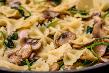 Delicious farfalle pasta with mushrooms, cheese and spinach with spices