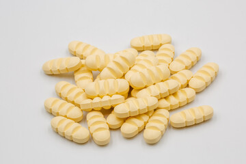 Yellow tablets with strips for dividing into four parts closeup.