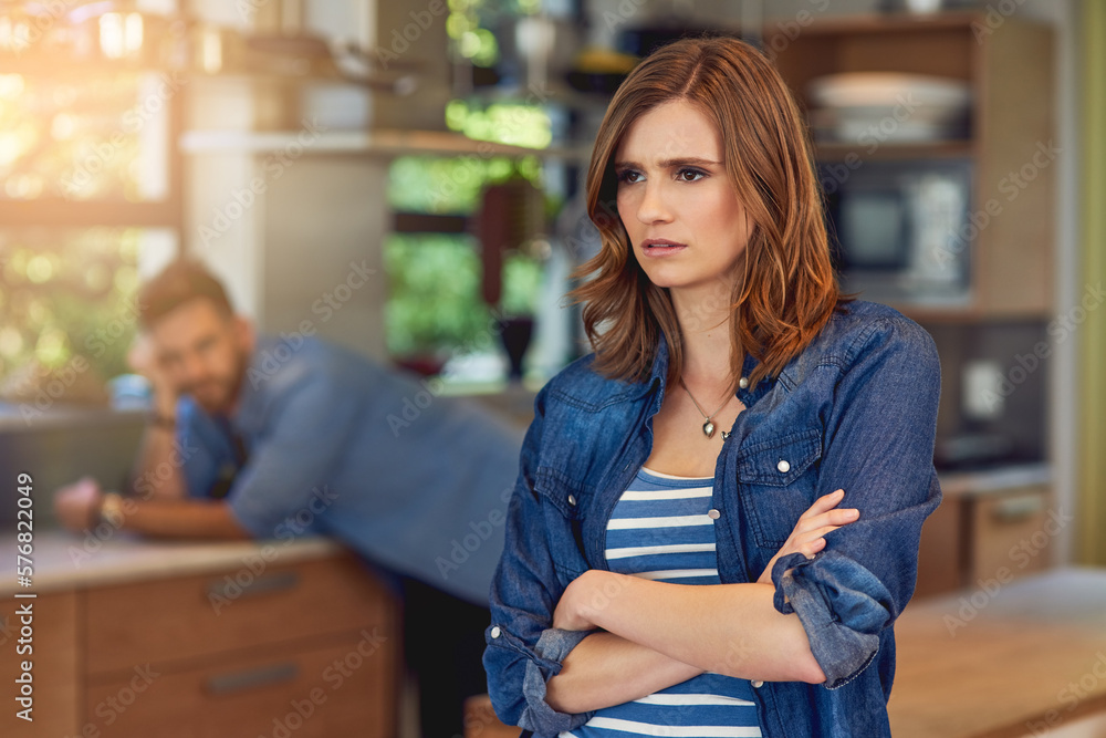 Canvas Prints When poor communication causes conflict. Shot of a young woman looking upset after a fight with her husband who is standing in the background.