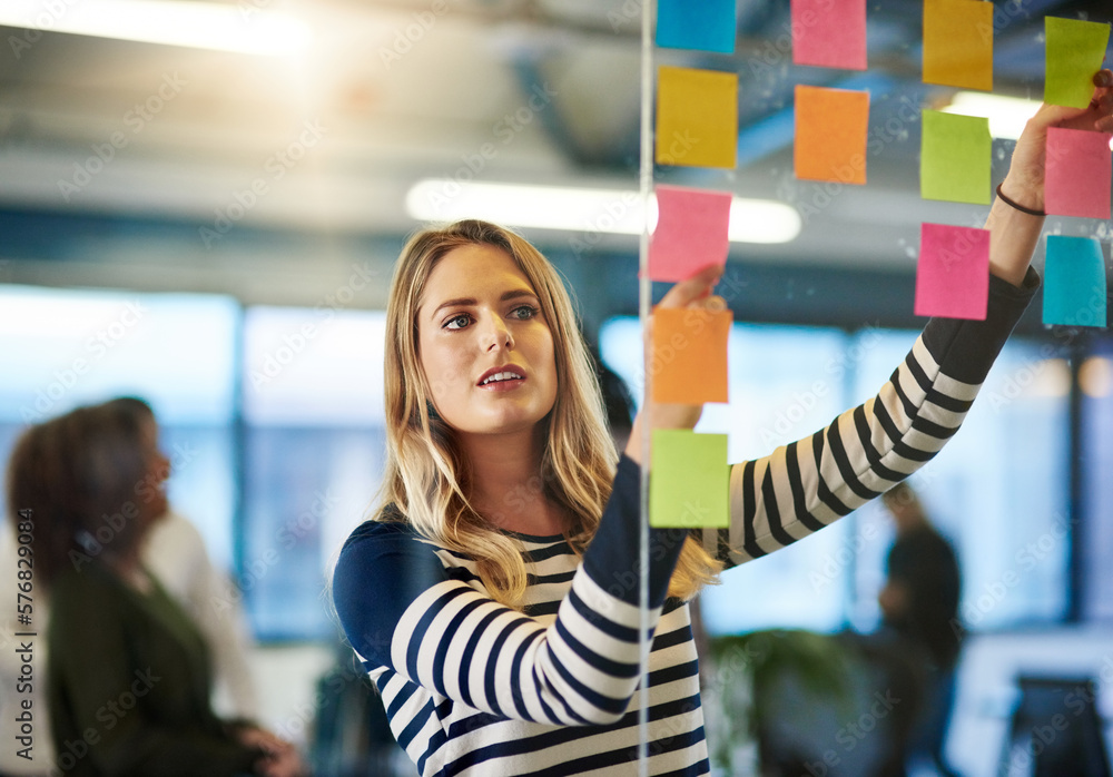 Poster attaining success with a well mapped out plan. shot of a young woman having a brainstorming session 