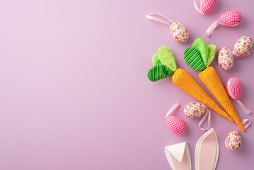 Easter concept. Top view photo of carrots easter bunny ears and textile easter eggs on isolated...