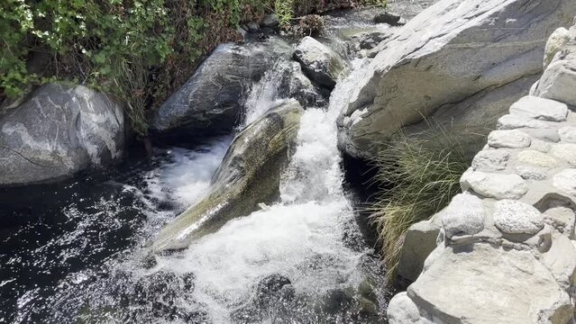 A clear bubbling brook flows over smooth rocks