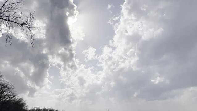 tilt up into early spring thunder clouds along a rural road