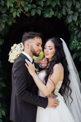 couple in love. stylish Groom in a wedding suit and the bride in a chic white dress. Wedding ceremony.