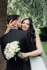 couple in love. stylish Groom in a wedding suit and the bride in a chic white dress. Wedding ceremony.