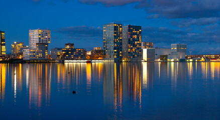 Waterfront city skyline with reflection in the lake at sunset, Almere, Flevoland, Netherlands