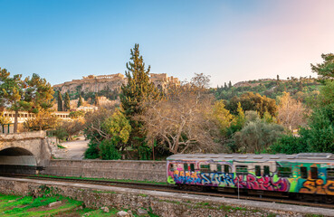 The Metro of Athens running along the Ancient Agora with the Acropolis in the background. in Athens, Greece.