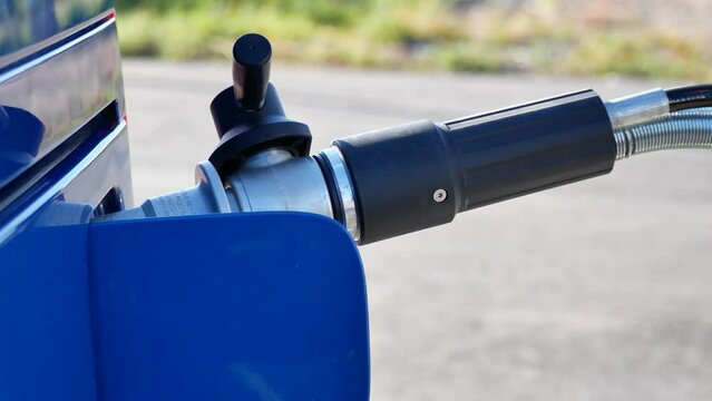 A man attaches a gas nozzle to a compressed natural gas CNG powered car