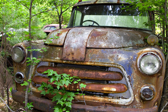 Old rusty American car in a scrap yard