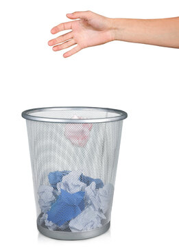 Hand throwing out paper into trashcan isolated on white background