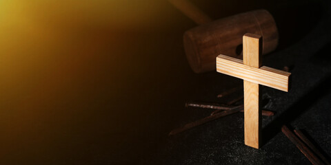 Wooden cross, nails and mallet on dark background with space for text. Good Friday concept