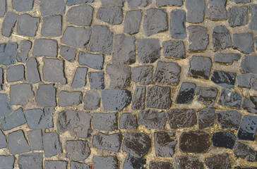 Wet black pavement pavement after rain. Textures and paving stones