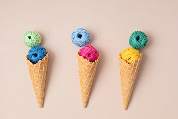 Colorful balls of organic cotton yarn waffle cones for ice cream . Recomforting hobby to reduce stress