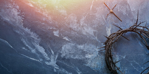 Crown of thorns and wooden cross on blue grunge background with space for text. Good Friday concept