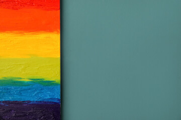 Painting of LGBT flag on blue wall