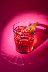 Cocktail on a pink background. Alcohol, party, drink in a beautiful glass.