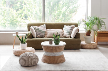 Fototapeta na wymiar Interior of cozy living room with green sofa, poufs and houseplants