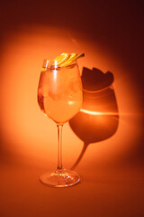 Cocktail on an orange background. Alcohol, party, drink in a beautiful glass.