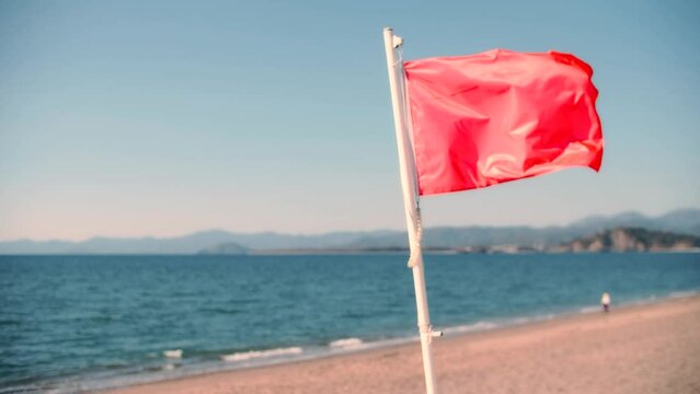 Red flag on the beach as a hazard of high surf or strong sea currents