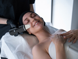 Obraz na płótnie Canvas Woman on ultrasonic cleaning procedure. Hardware cosmetology. 