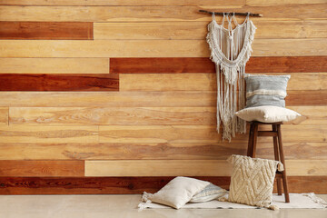 Stylish decorative pillows near wooden wall