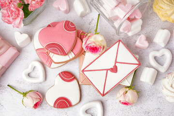 Composition with tasty cookies, marshmallows and rose flowers on light background. Valentine's Day celebration