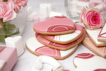 Obraz na płótnie Canvas Tasty cookies, marshmallows and rose flowers on light background, closeup. Valentine's Day celebration